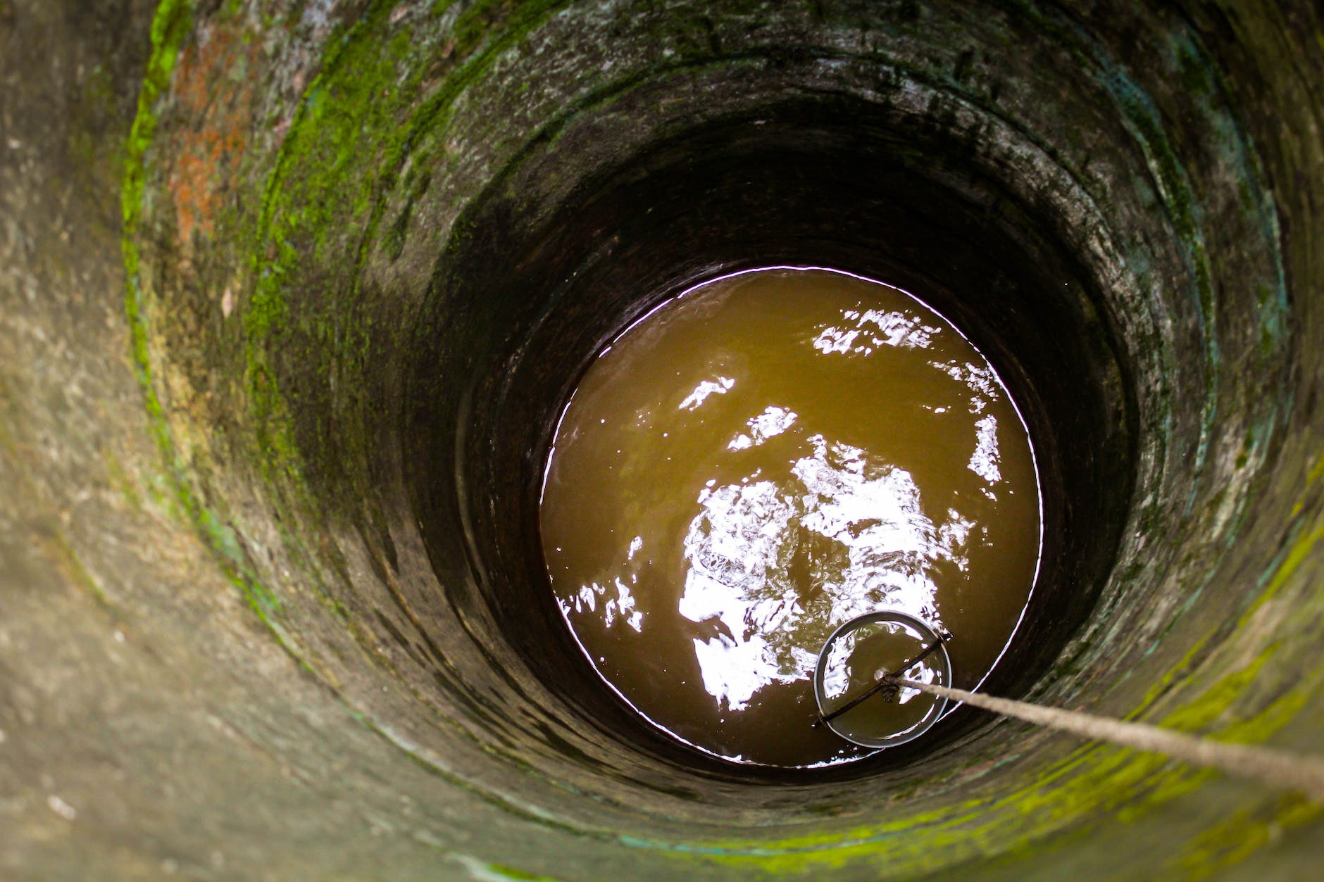 bucket lowered on rope into well